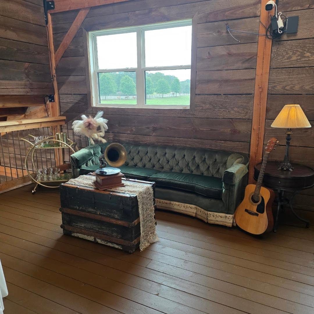 Green velvet tufted sofa and wooden trunk in a rustic barn setting