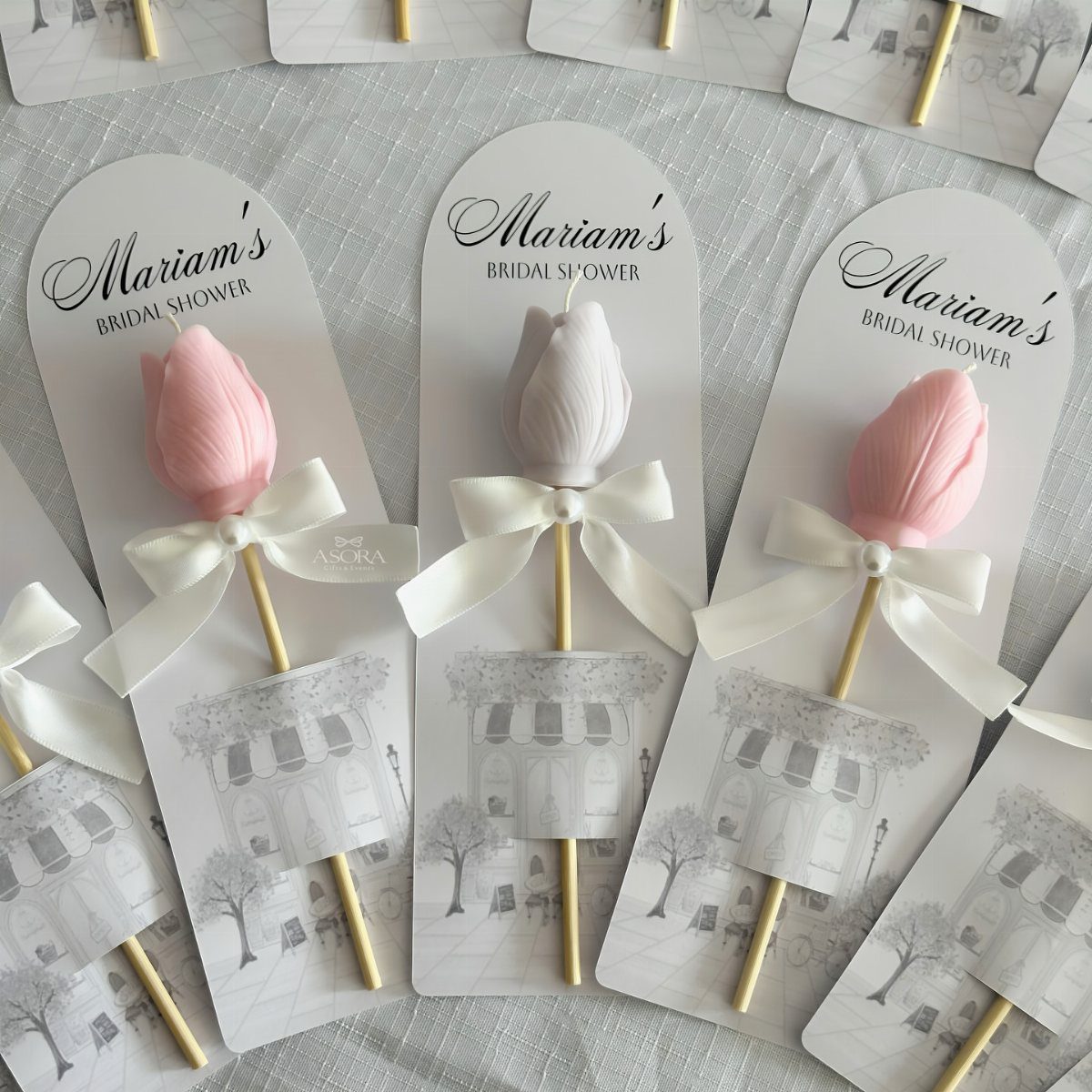 Tulip-shaped pink and white candles on sticks with bridal shower cards.