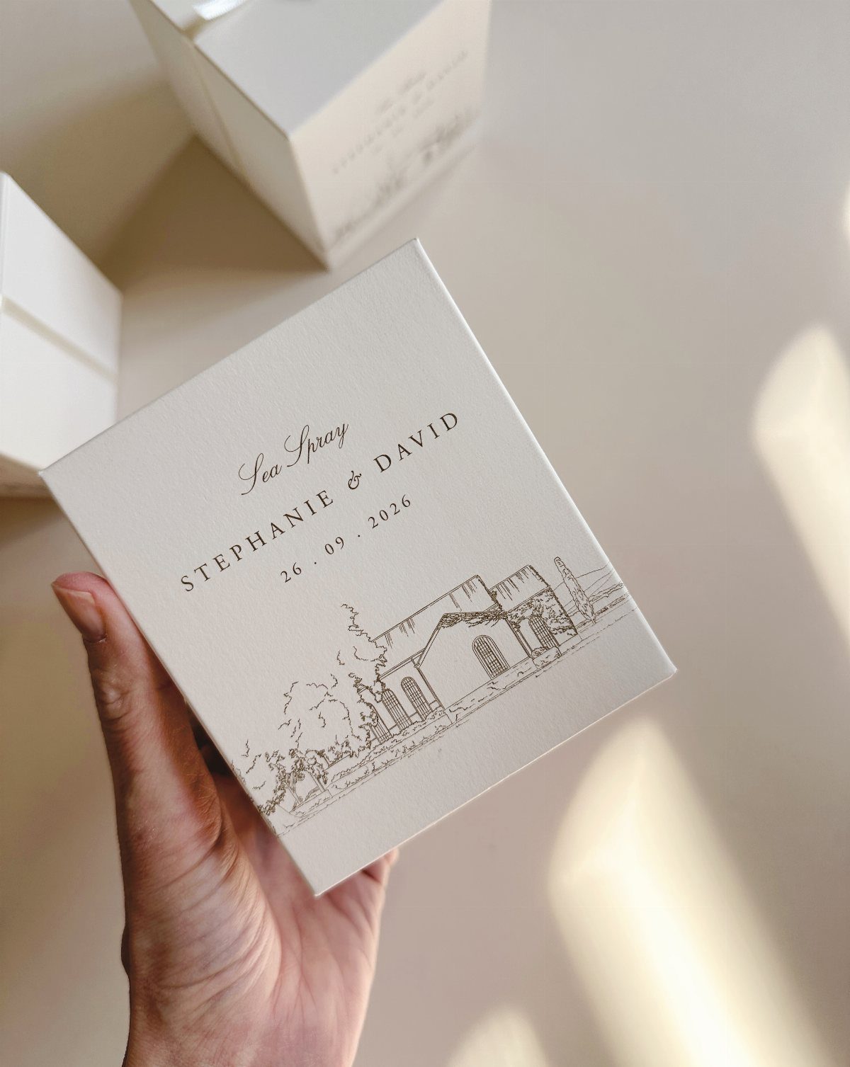 White candle gift box with custom wedding date and couple's names on label.