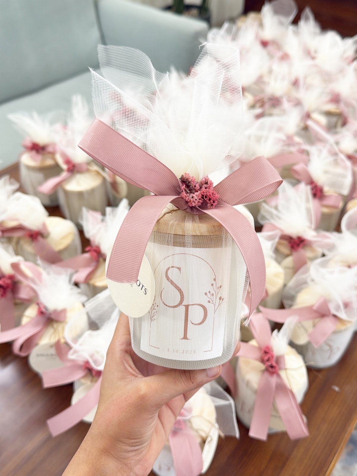 Small glass jar candle with initials, wrapped in tulle and pink ribbon.