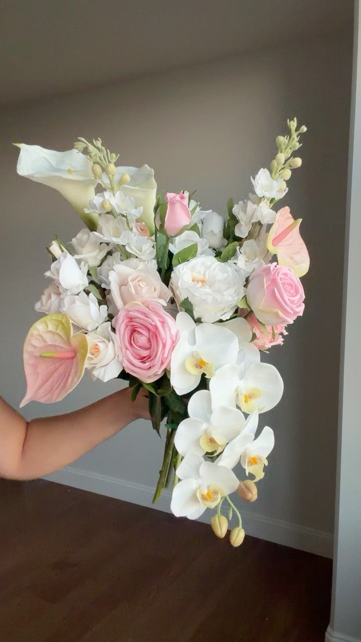 Cascading bridal bouquet with white orchids, pink roses, and white calla lilies.