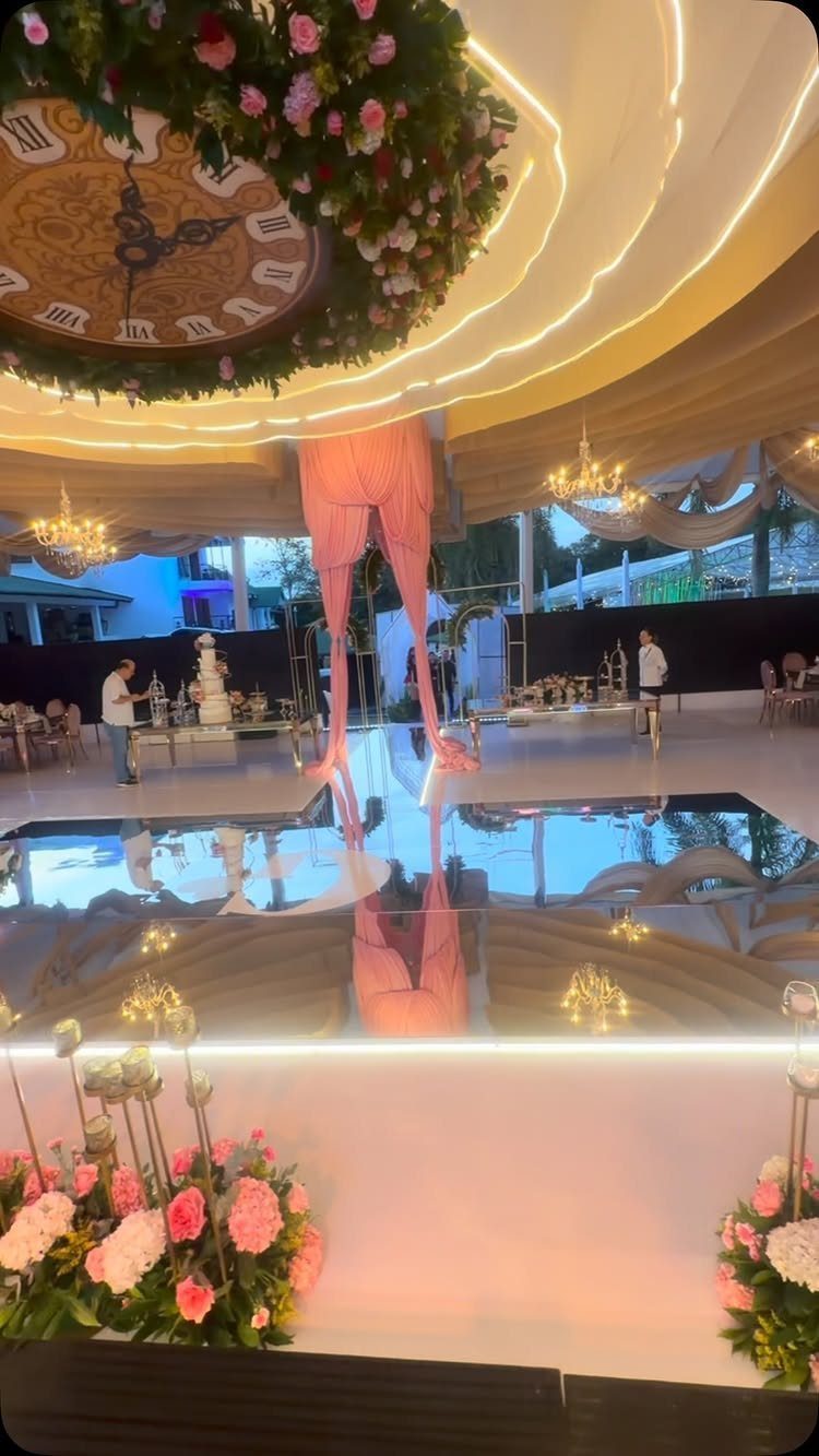 Reflective white dance floor in a luxury event space with floral decorations.