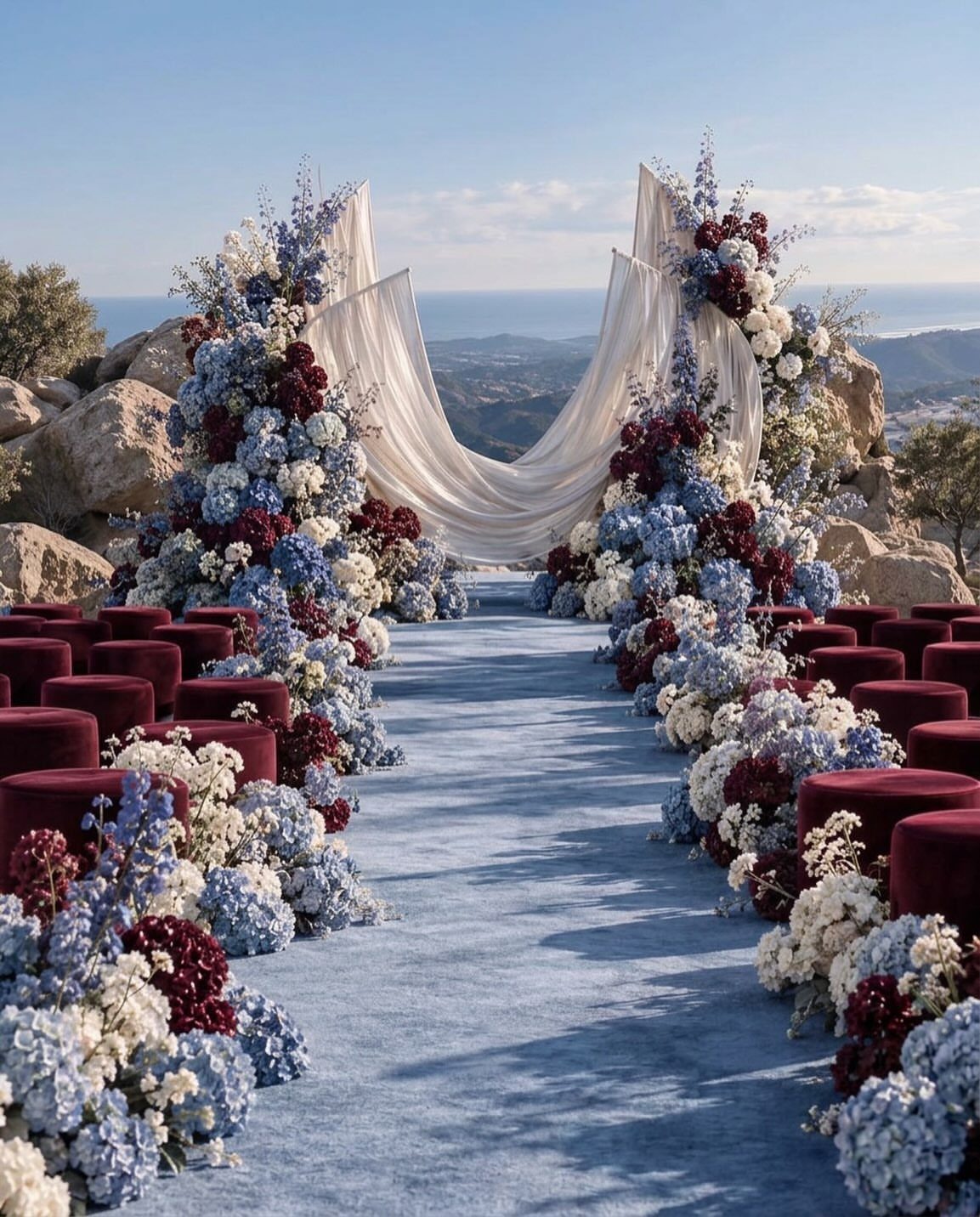 Dusty blue aisle runner and burgundy velvet seats with blue and burgundy floral arrangements.