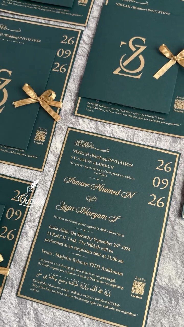 Emerald green wedding invitations with gold foil lettering and small gold ribbon bows.