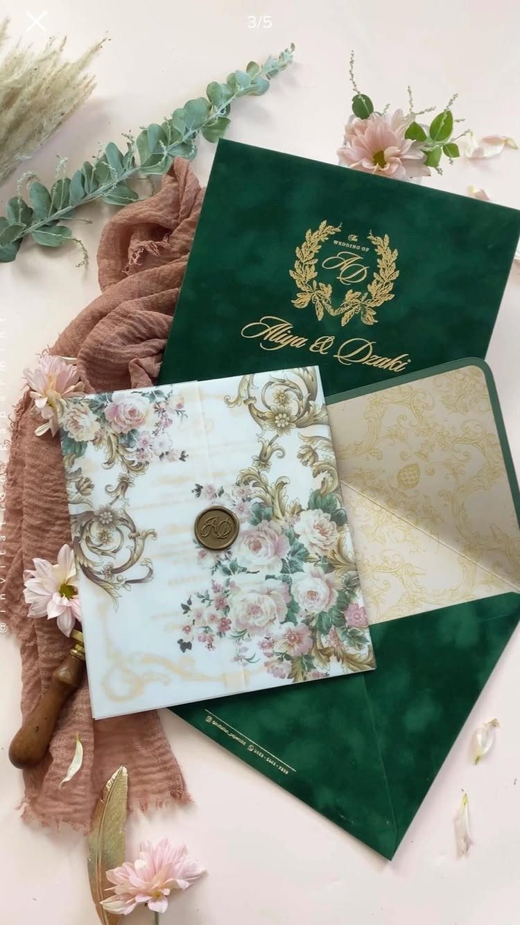 Emerald green velvet wedding invitation with gold foil lettering and floral stationery cards.