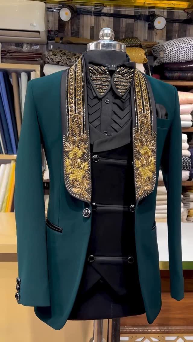 Emerald green tuxedo jacket with gold embroidered lapels and black waistcoat on a mannequin