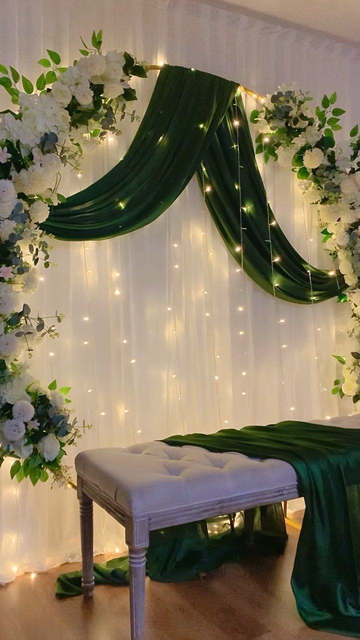 Emerald green velvet wedding arch with white roses and twinkling fairy lights