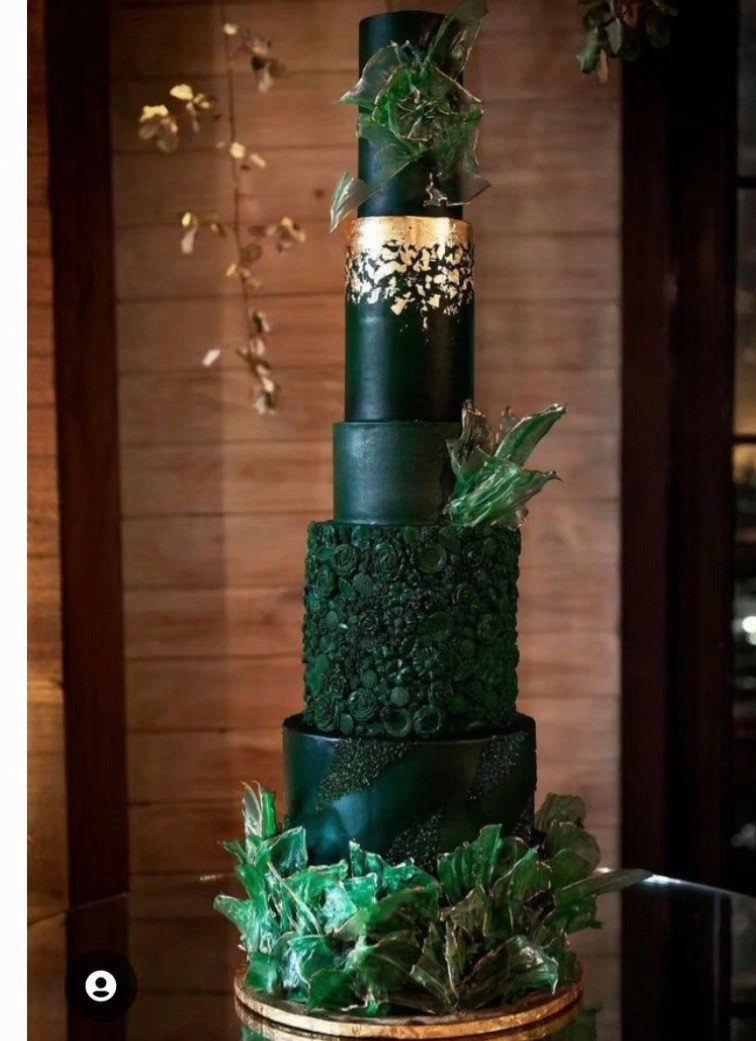 Emerald green multi-tiered wedding cake with gold accents and crystalline sugar decorations.