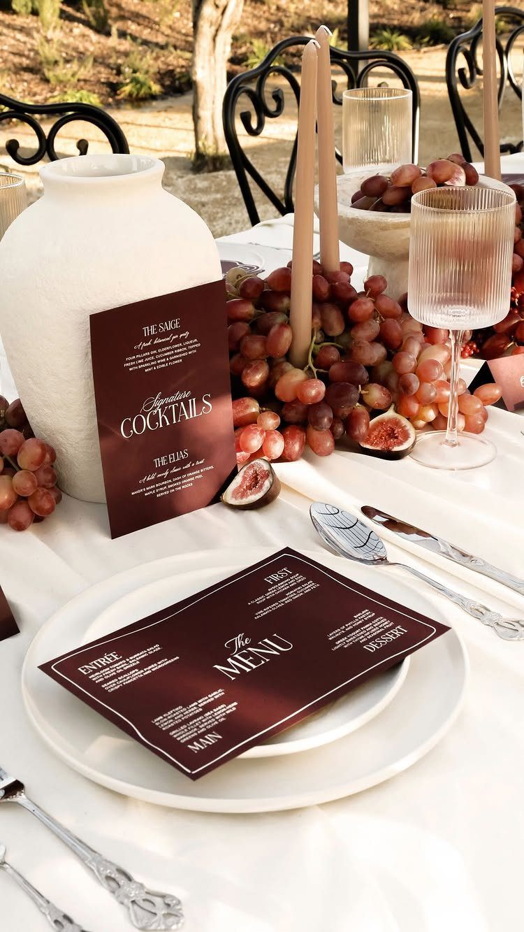 Red grapes and sliced figs arranged as a centerpiece on a white table.