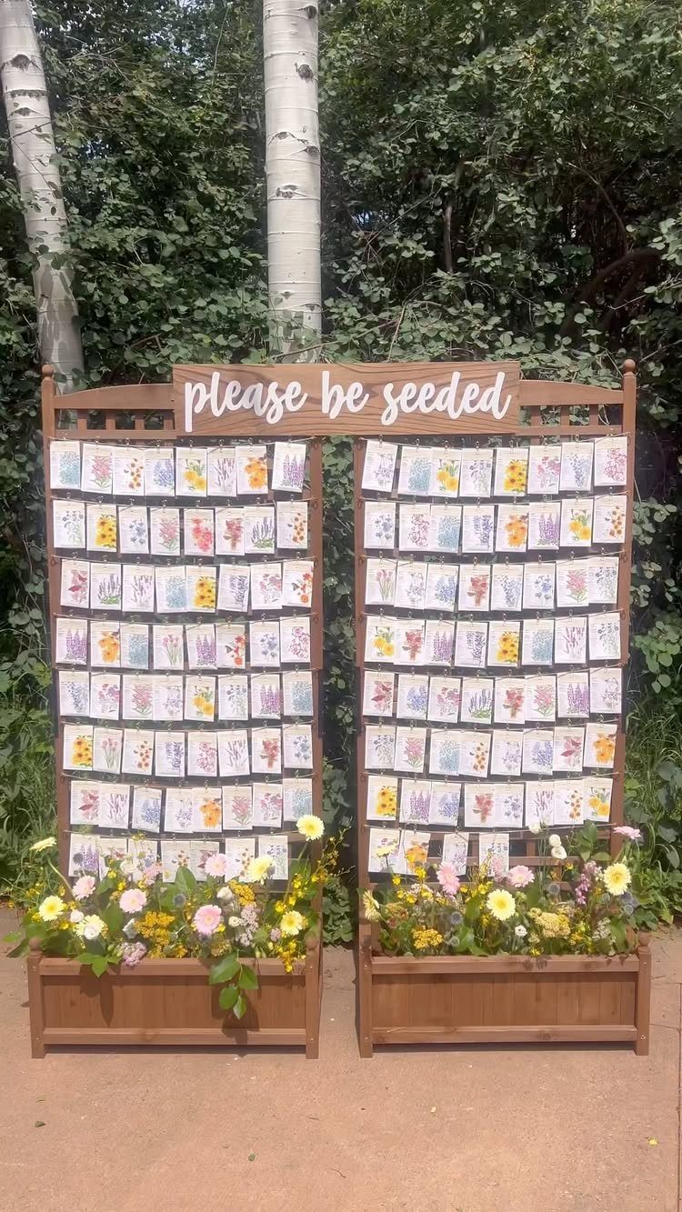 Wooden display stand holding rows of colorful seed packets with floral planter boxes.