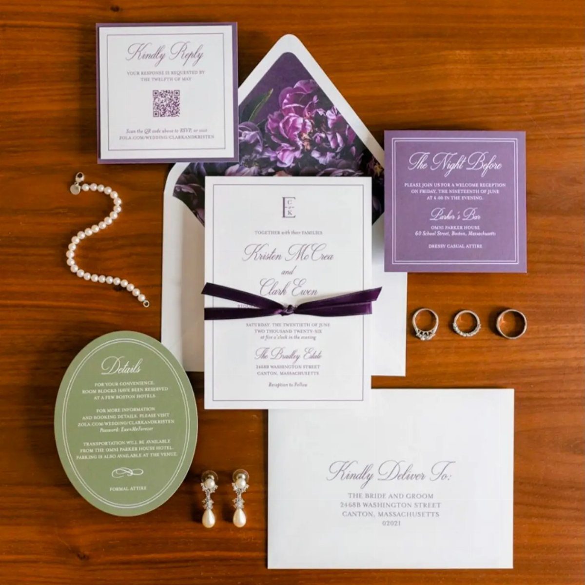 Wedding stationery set with purple and green cards, pearls, and rings on wood.
