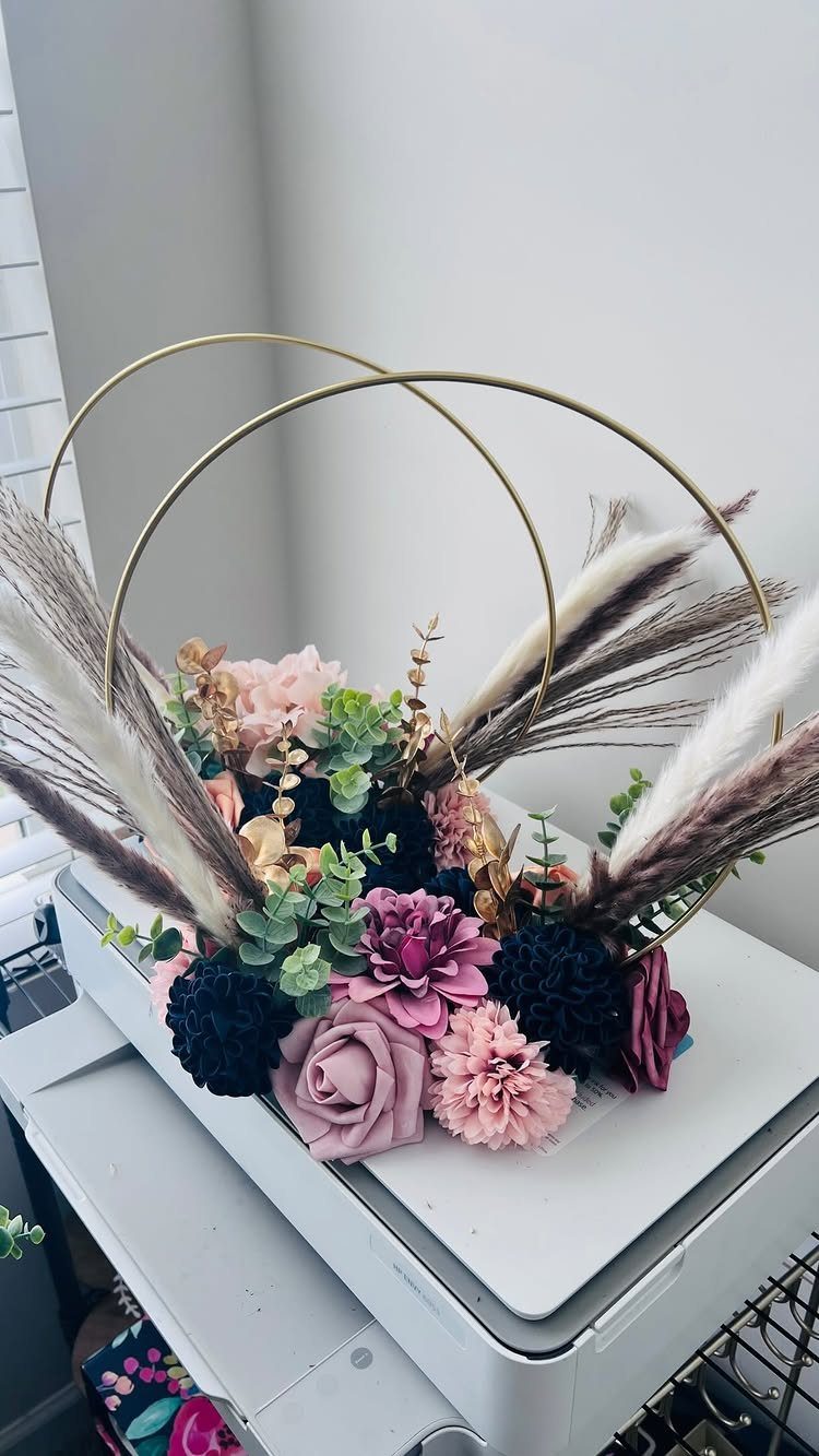 Floral arrangement with navy blue and blush pink flowers in gold hoops.