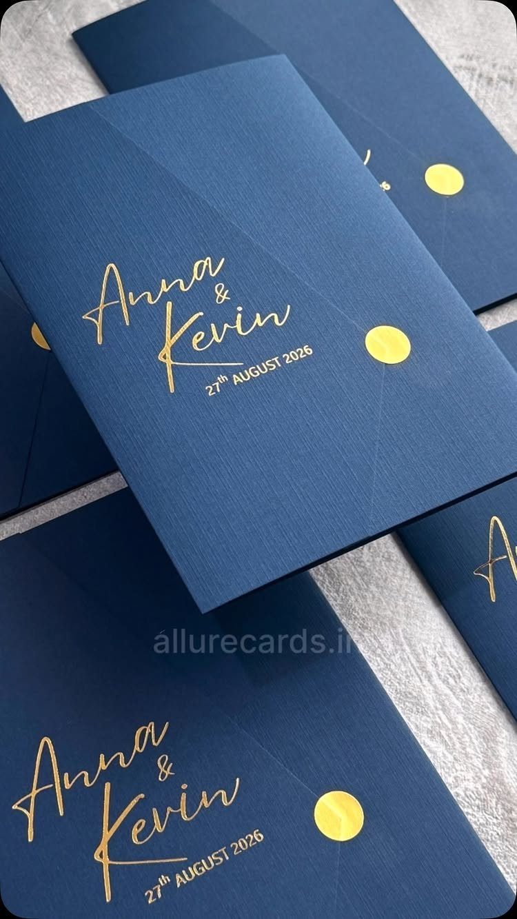 Navy blue wedding invitations with gold foil calligraphy and gold circular seals.