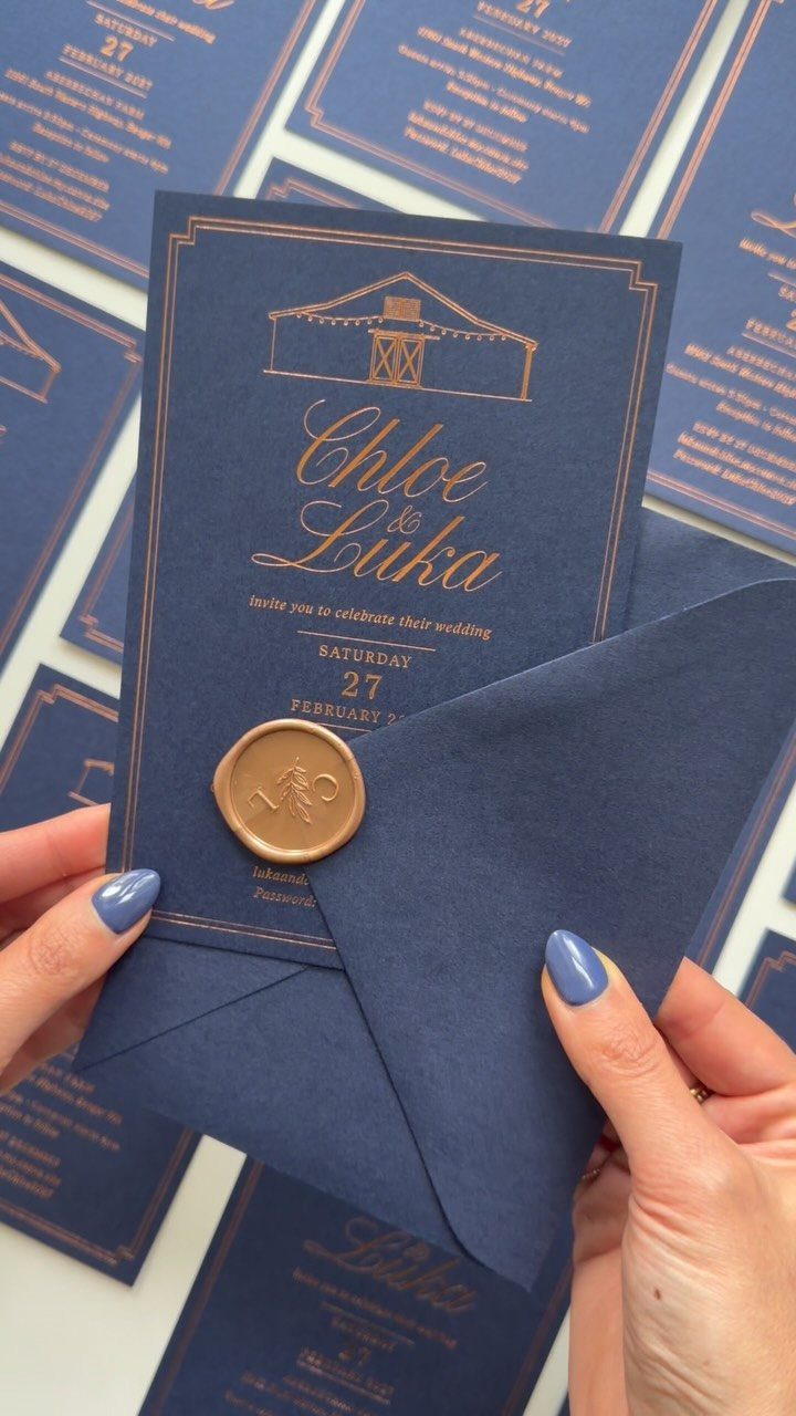 Navy blue wedding invitation with copper foil lettering and a copper wax seal.