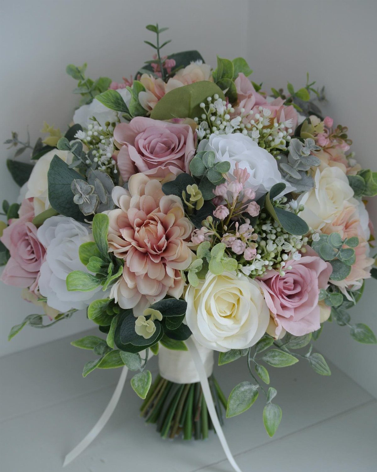 Bridal bouquet with pink and white roses and a peach dahlia flower.