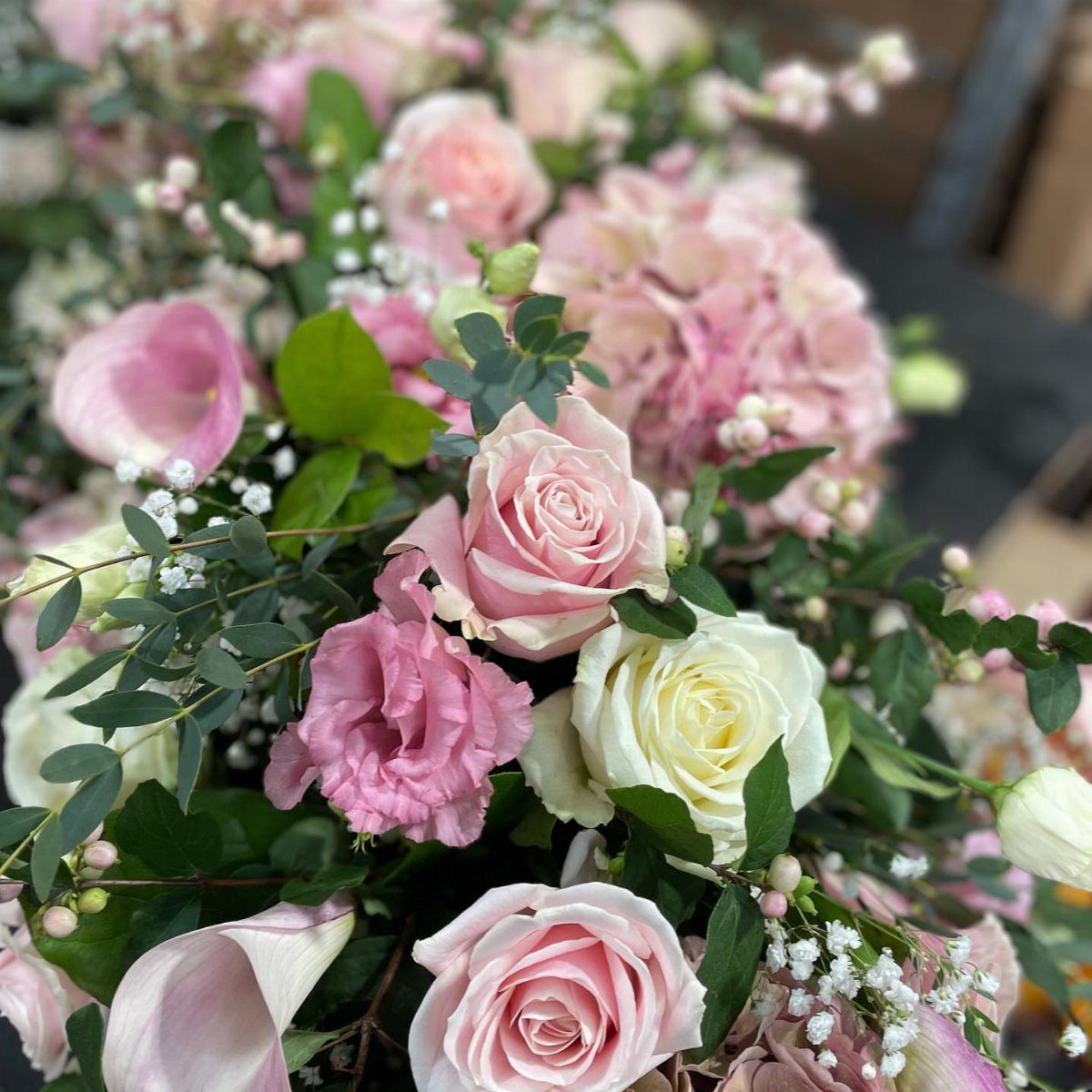 Pink and white roses with pink hydrangeas and green leaves in a bouquet