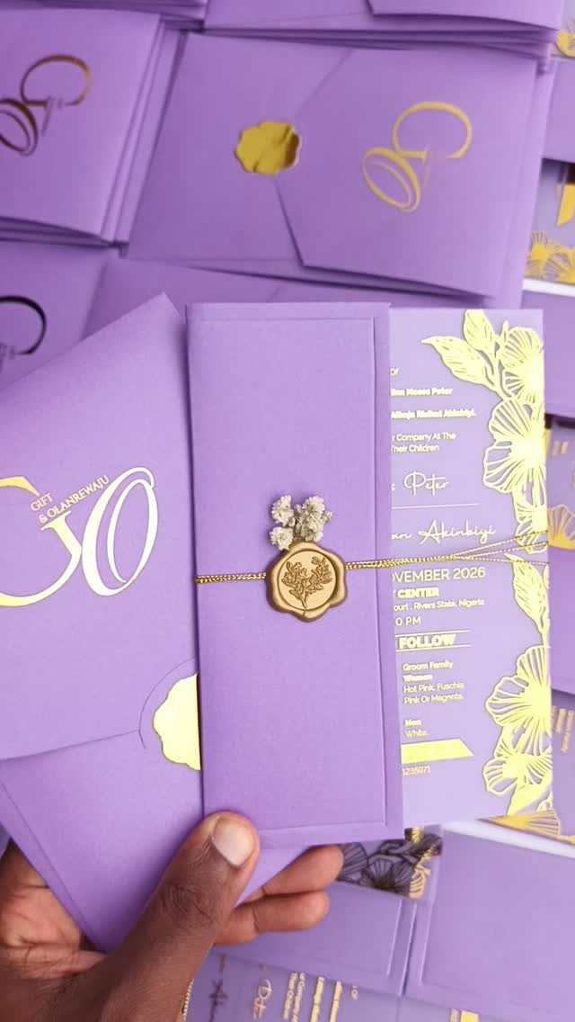 Purple wedding invitation with gold foil text and a gold wax seal.