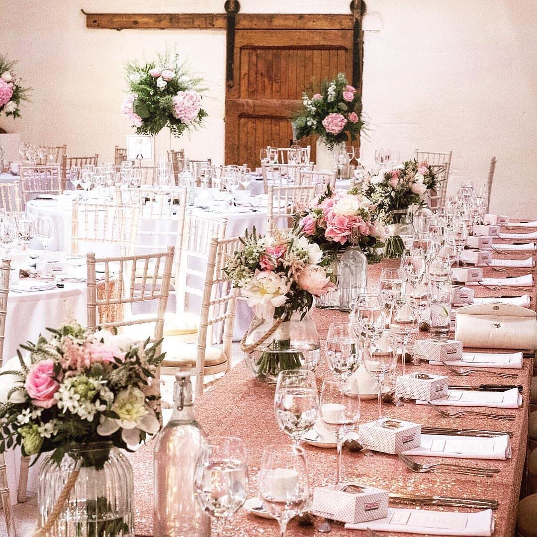 Rose gold sequin tablecloth on a wedding banquet table with pink floral centerpieces