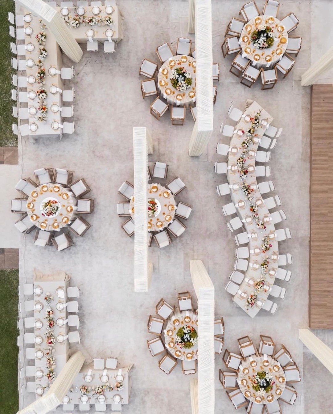 Aerial view of wedding reception with round and curved tables on a patio