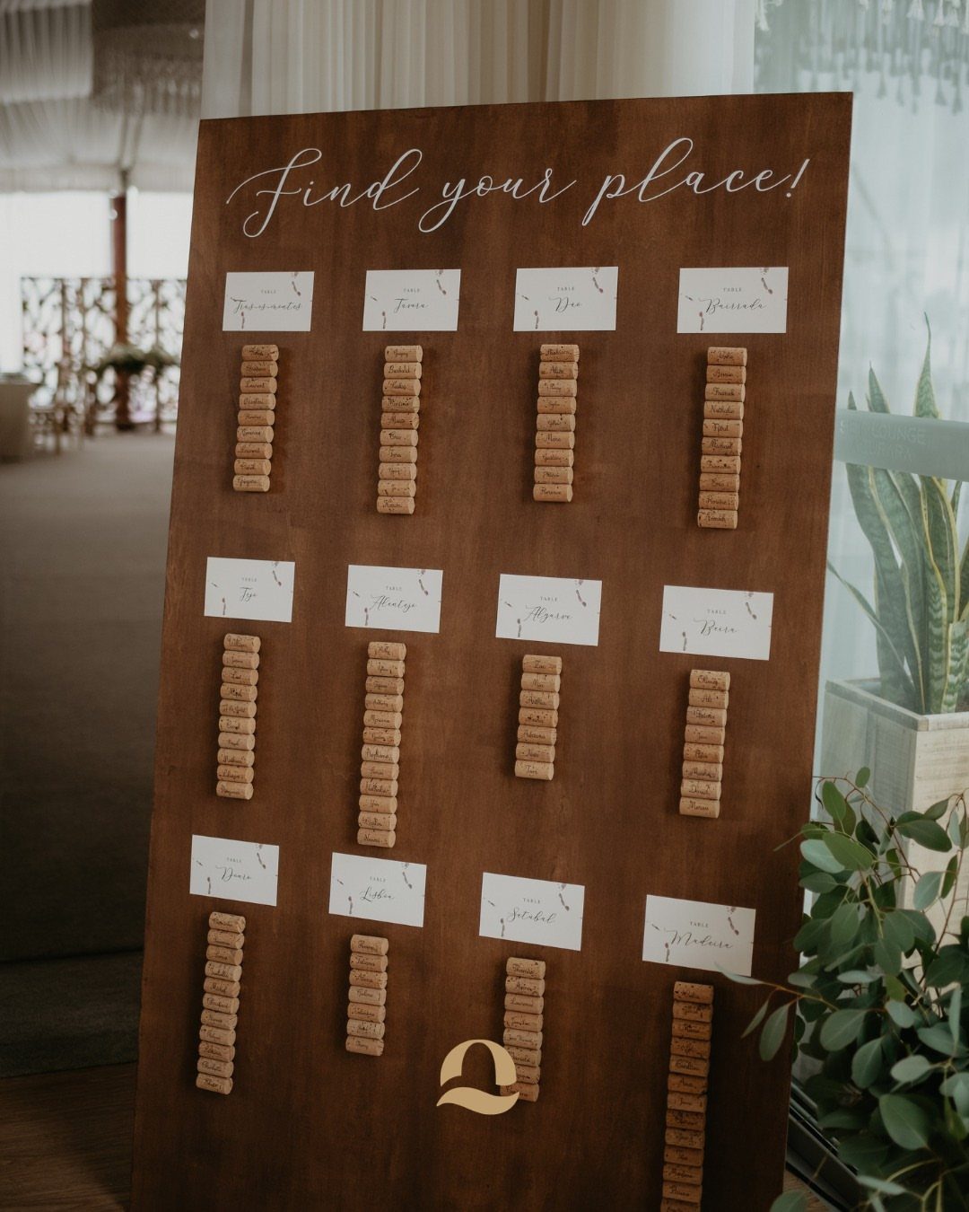 Wooden seating chart board with white cards and vertical columns of wine corks.