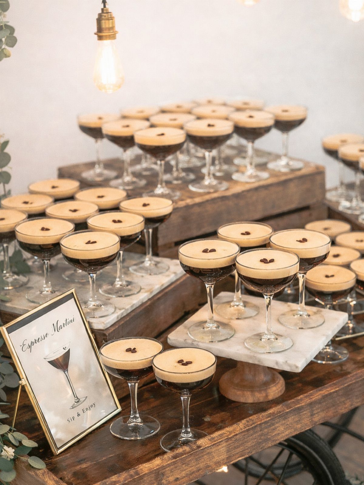 Espresso martinis with foam and coffee beans on rustic wooden and marble displays.