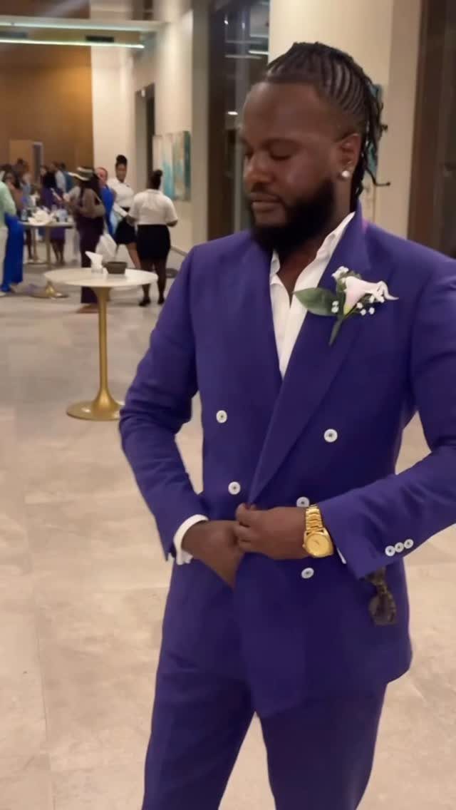 Man in a royal blue double-breasted suit with a white shirt and boutonniere.