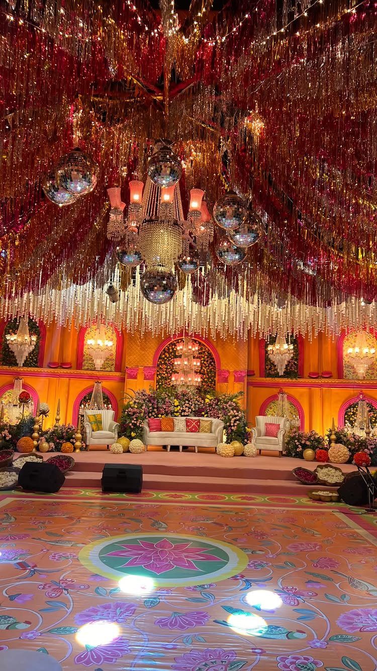 Mirrored disco balls and a crystal chandelier hanging from a shimmering tinsel ceiling.