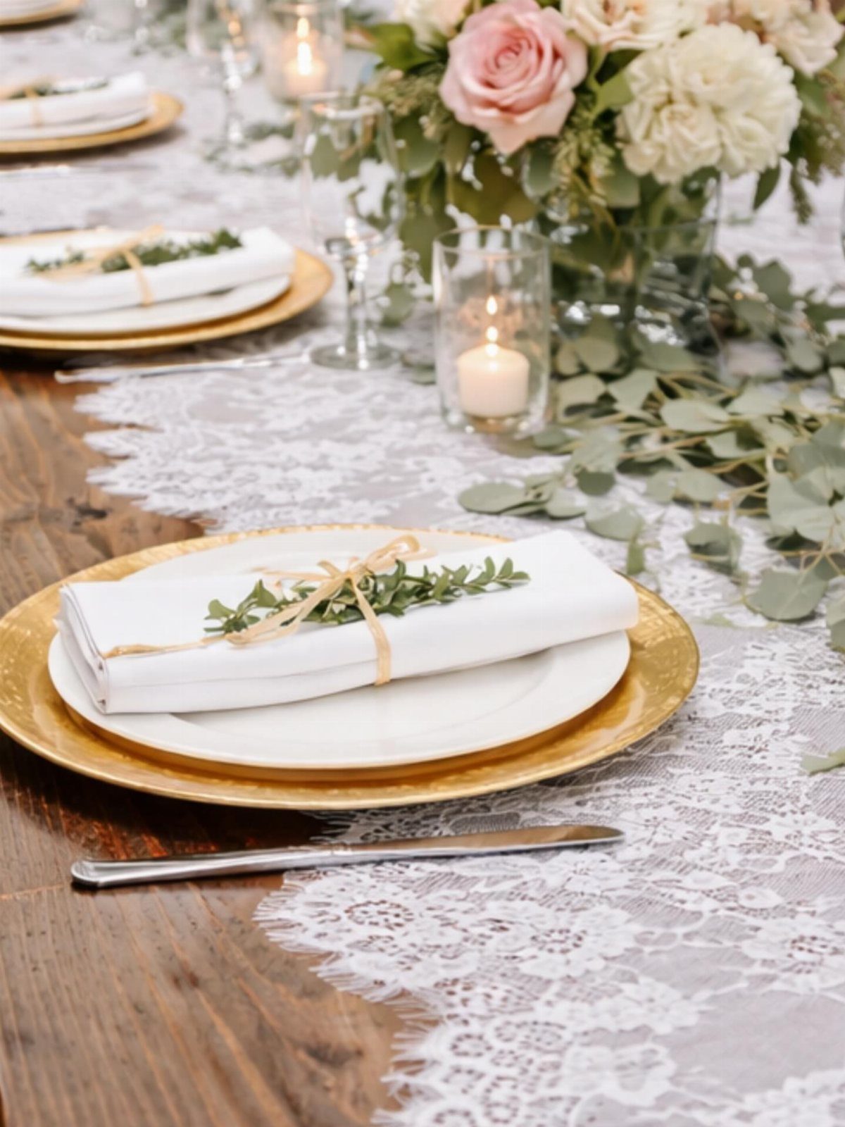 White lace table runner on a wooden table with gold plates and flowers