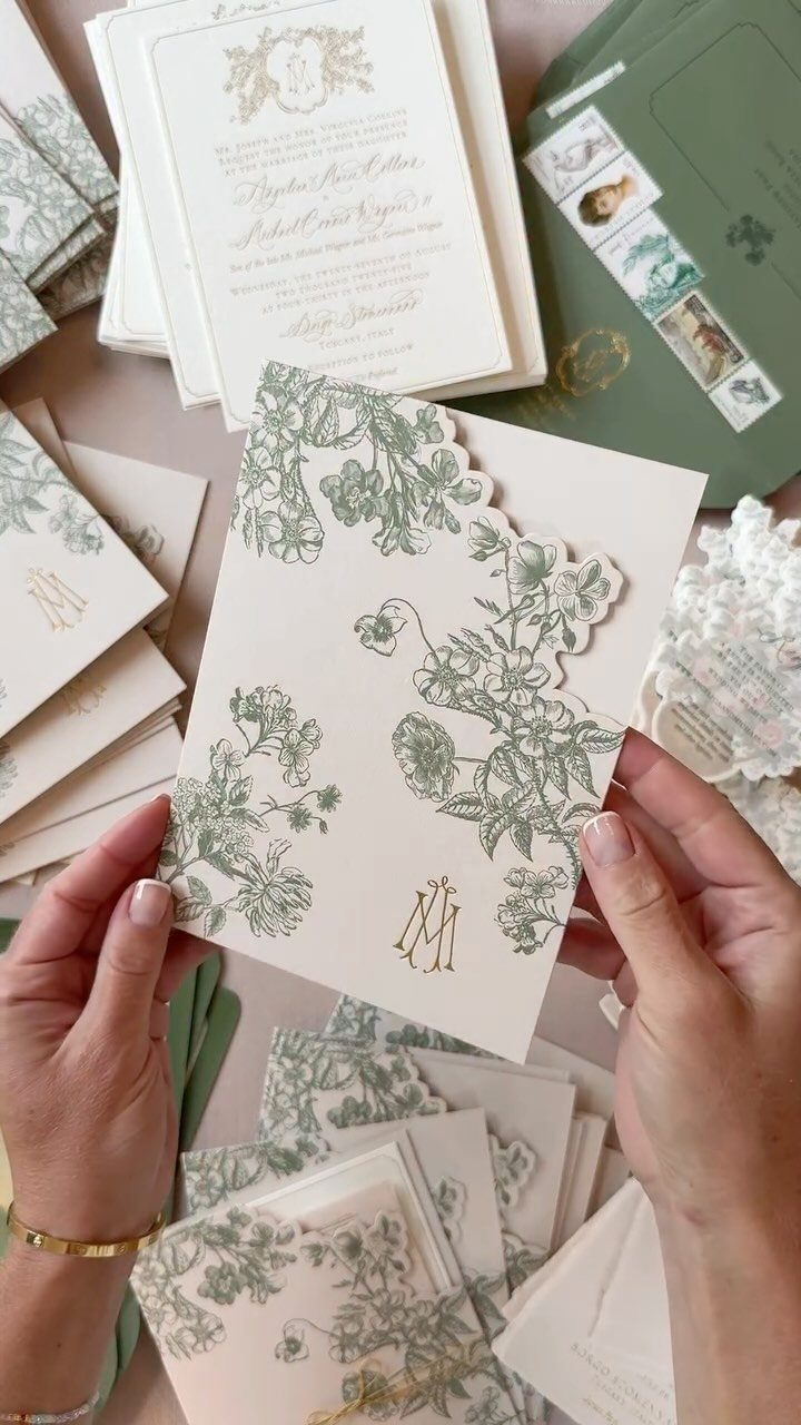 Cream wedding invitations with green botanical illustrations and gold foil lettering.