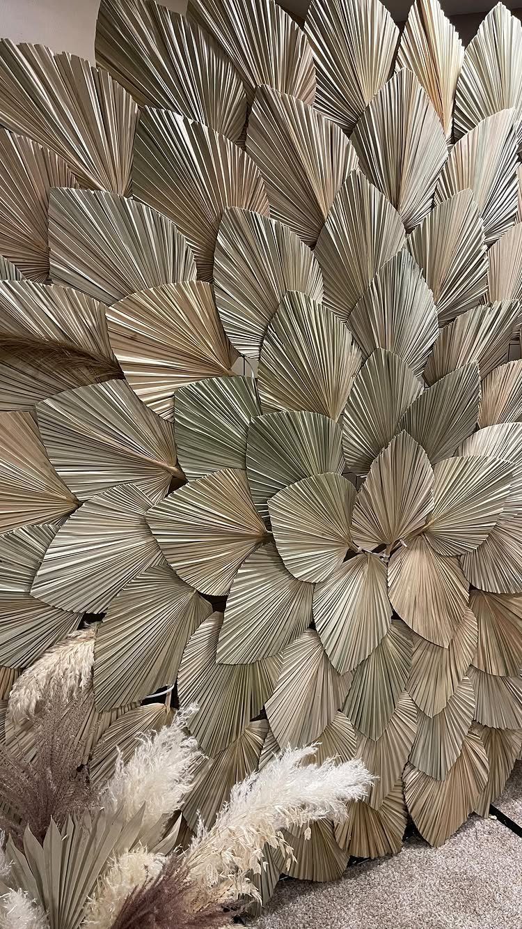 Dried fan palm leaves arranged as a textured wall backdrop with pampas grass.