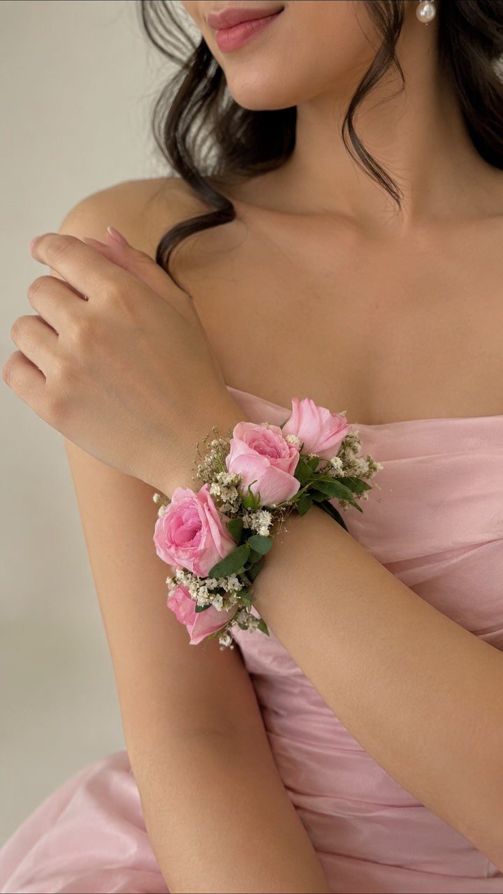 Pink rose and baby's breath corsage worn on a woman's wrist