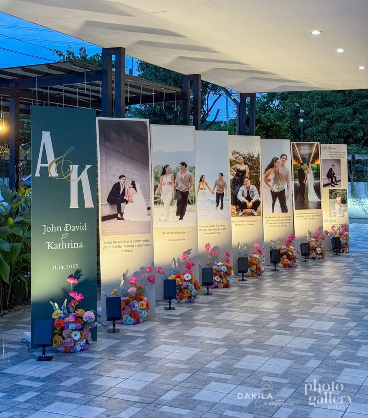 Vertical wedding photo banners with floral arrangements on a tiled outdoor patio.