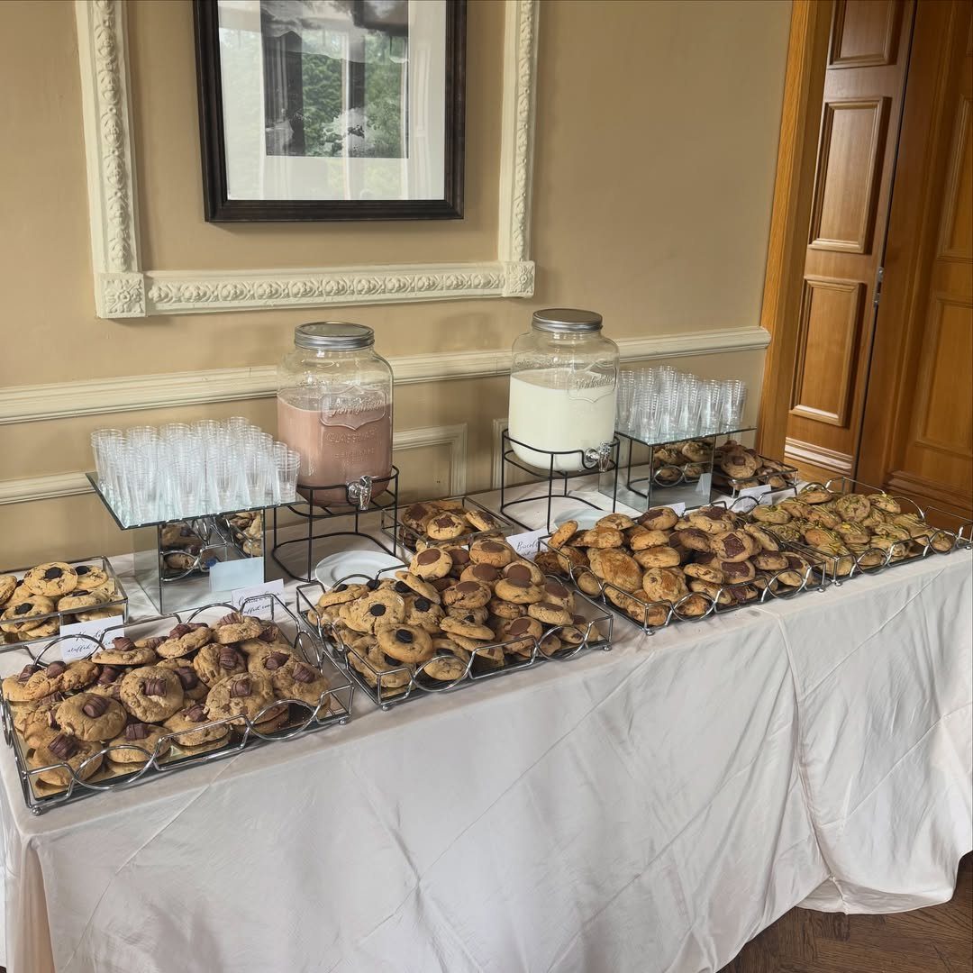 Cookies and milk bar with trays of chocolate chip cookies and milk dispensers.