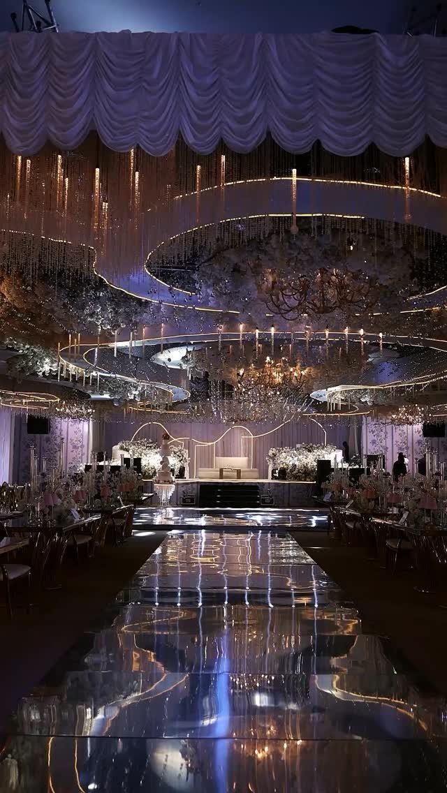 Lavish wedding venue with mirrored aisle and glowing circular ceiling installations