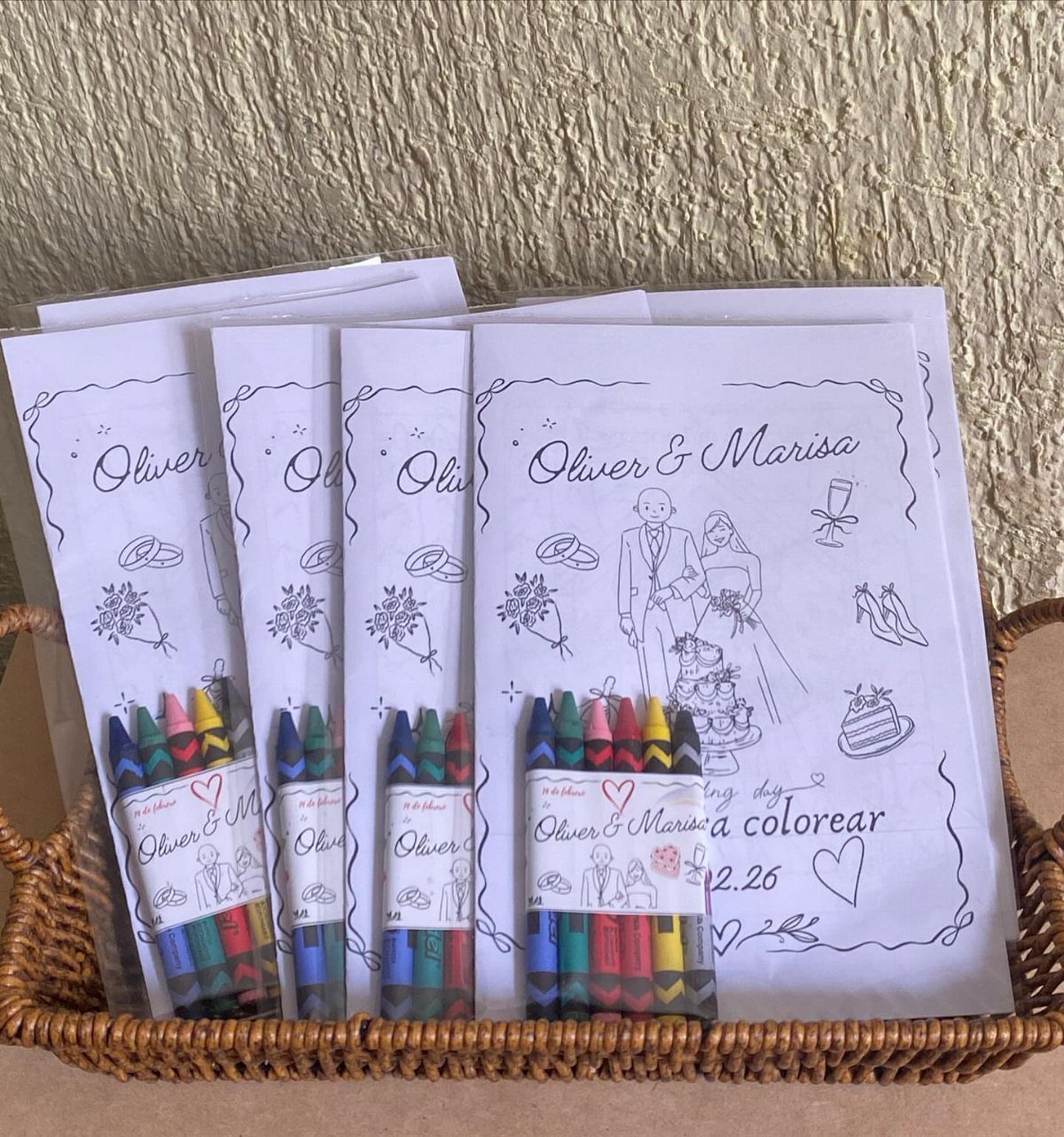 Coloring pages and crayons in a wicker basket for a wedding activity.
