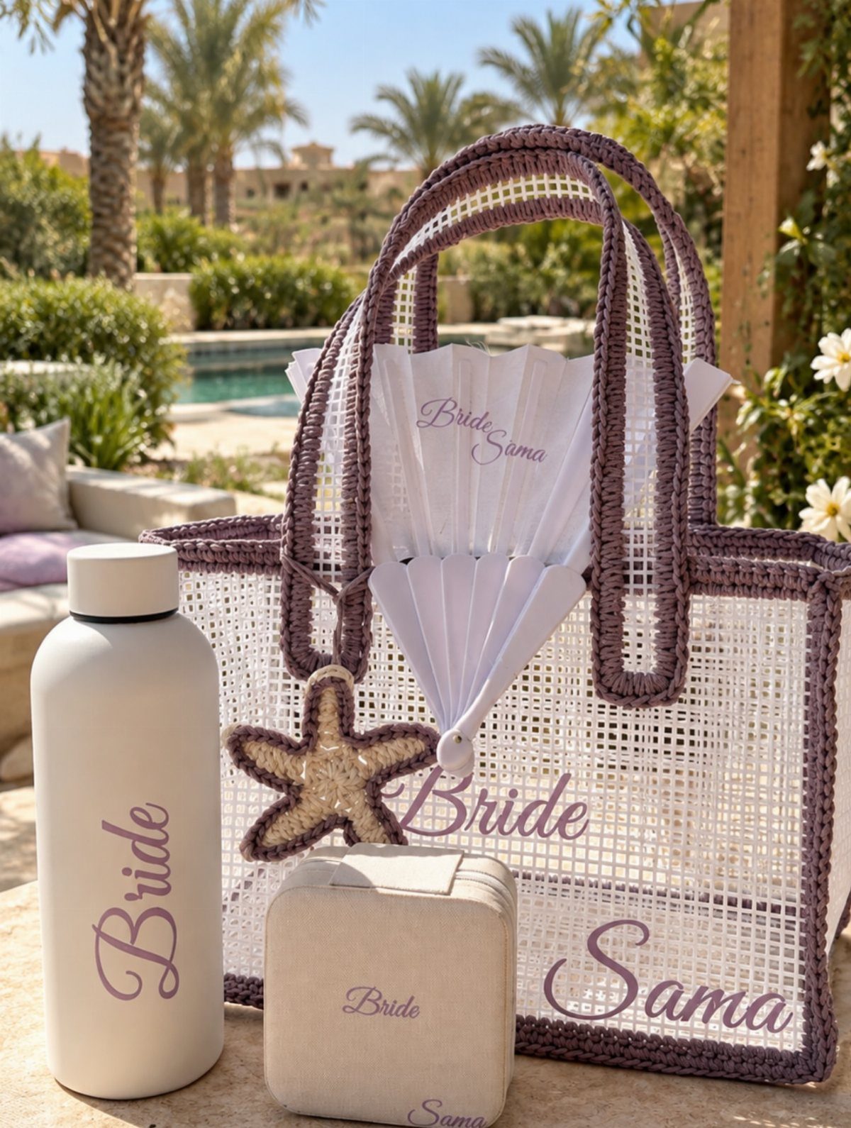 White mesh beach bag with purple trim and personalized bridal accessories by a pool.