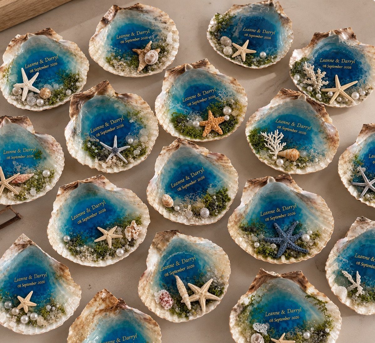 Seashell resin ornaments with blue ocean swirls, starfish, and gold wedding names.