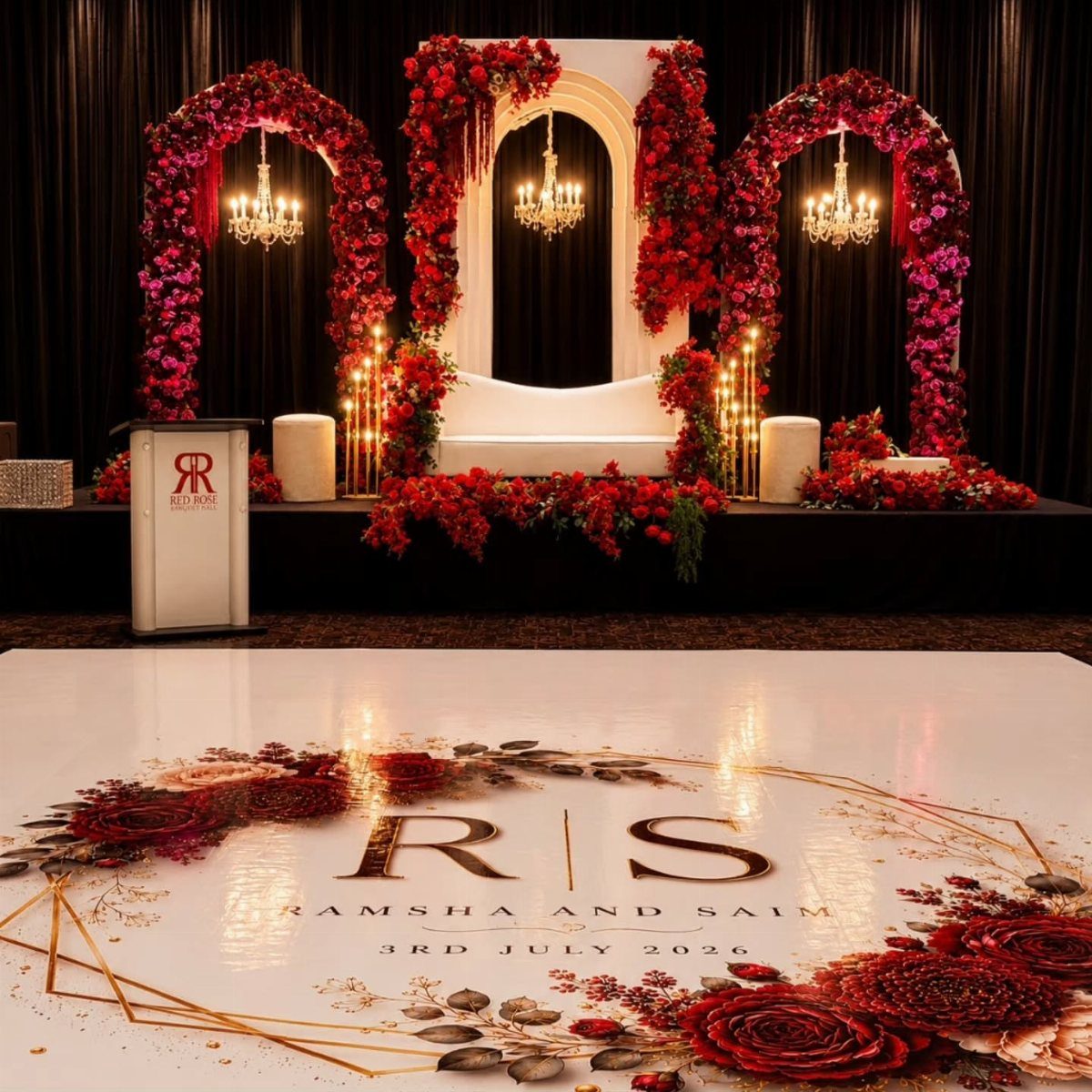 Red floral arches and chandeliers framing a wedding stage with a personalized dance floor.