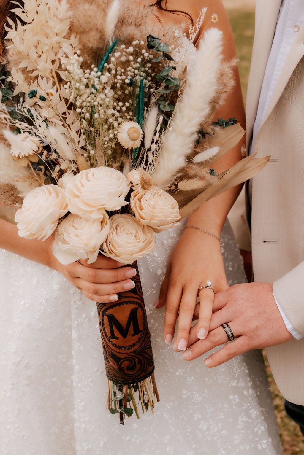 Rustic wedding bouquet with cream roses and pampas grass wrapped in embossed leather.