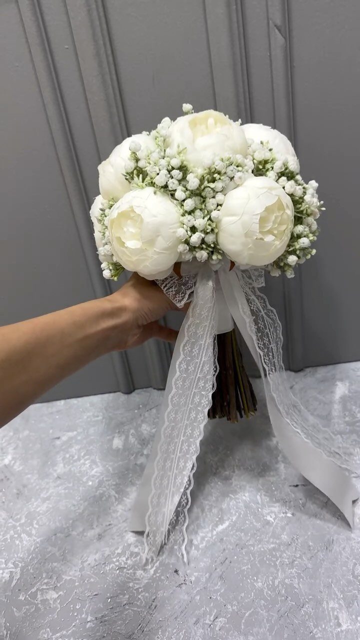 White peony bridal bouquet with baby's breath and white lace ribbon.