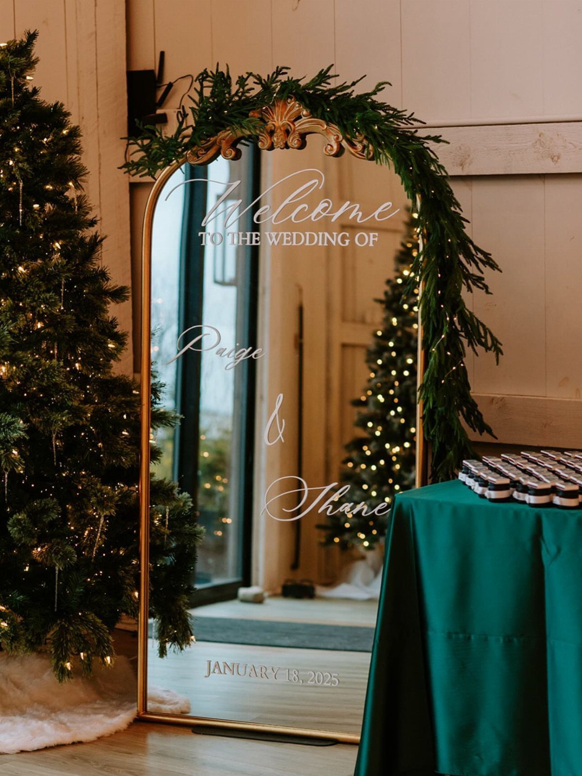 Gold arched welcome mirror with pine garlands next to a lit Christmas tree
